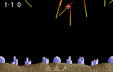 Super Missile Command amb trajectòries vermelles i grogues que baixen cap a edificis i cúpules sobre el terreny.