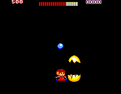 Alex Kidd al costat d’una Miracle Ball oberta en un espai fosc.