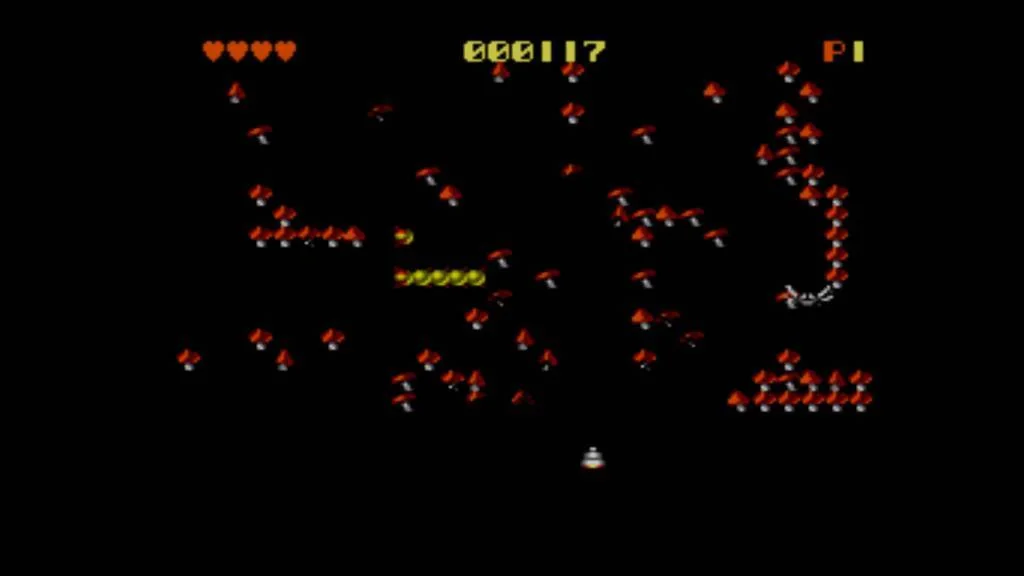 Partida de Centipede amb un centpeus, una aranya, bolets i la base del jugador.