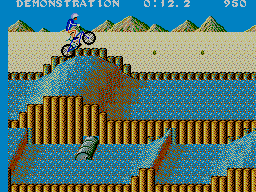 Ciclista de BMX saltant sobre una pista de terra al costat de l’aigua.