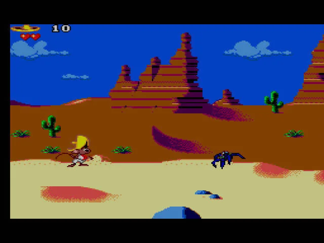 Speedy Gonzales davant d’una aranya en un desert amb cactus i formacions rocoses.