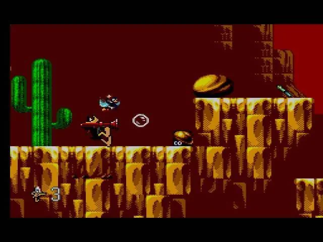 Daffy dispara una bombolla contra un enemic en un canó amb cactus i plataformes.