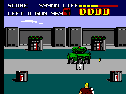 Duke combat contra un vehicle blindat verd davant d'un complex militar.