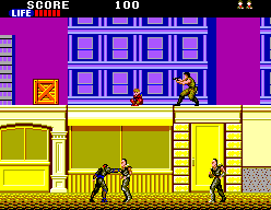 Joe Musashi combat al carrer mentre diversos enemics ocupen la vorera i una plataforma elevada.