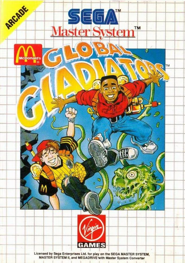 Coberta frontal europea de Global Gladiators per a Sega Master System, amb Mick i Mack davant d’una criatura verda.