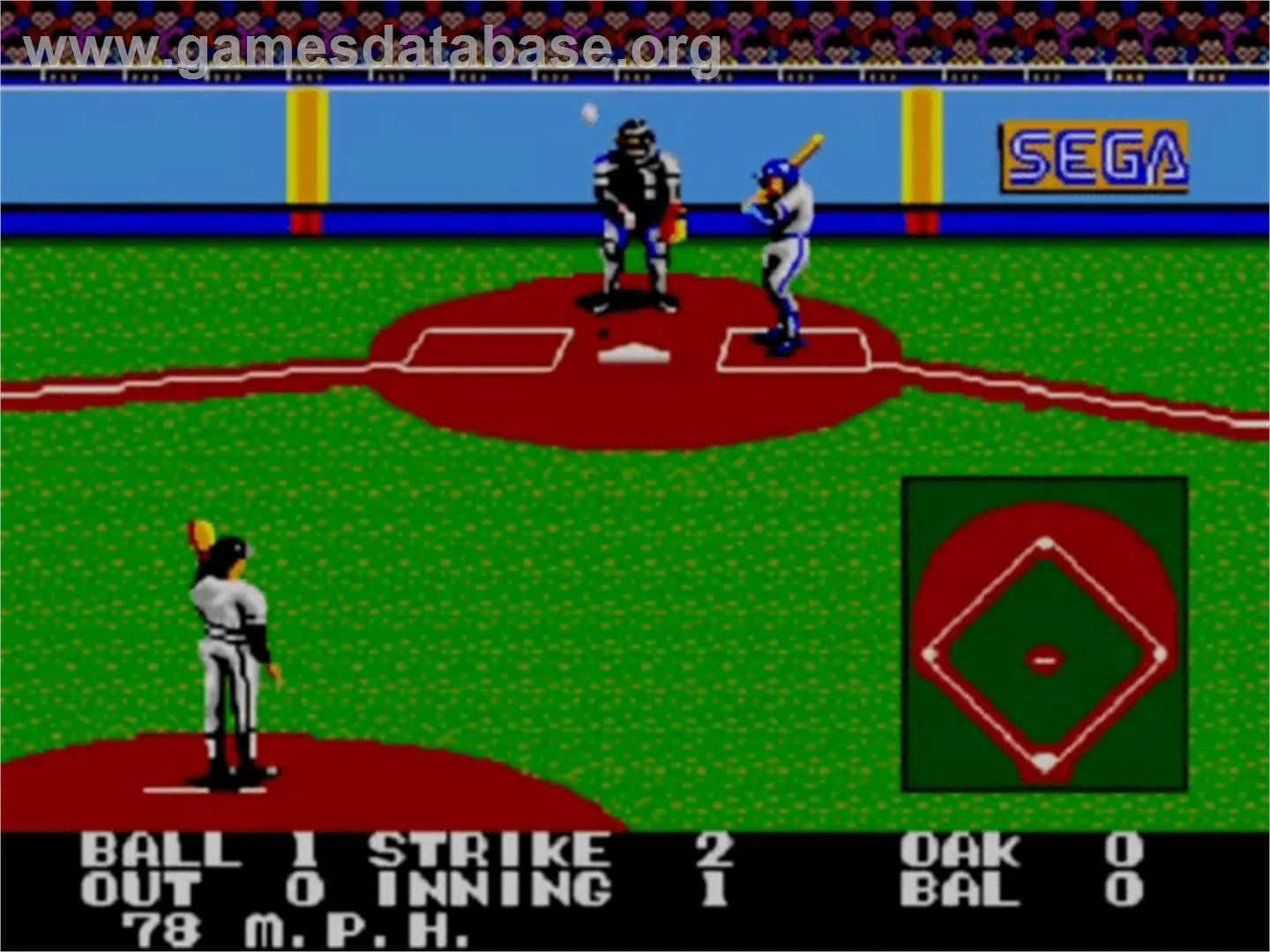 Partida de Great Baseball vista des del llançador, amb batedor, receptor, àrbitre, diamant i indicadors del recompte.