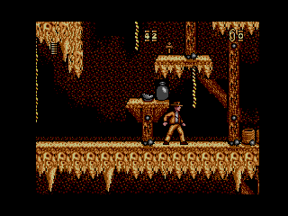 Indiana Jones davant d’un pedestal amb un objecte de missió dins d’una caverna.
