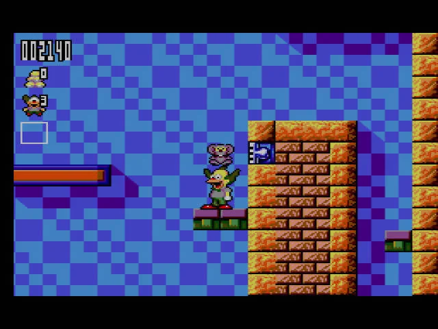 Krusty sosté un objecte sobre una plataforma verda al costat d’un mur de maó.