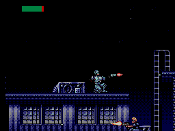 RoboCop dispara ajupit des d’un terrat mentre un enemic respon des del carrer inferior.