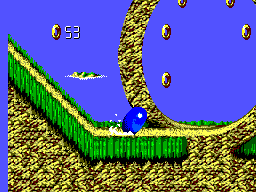 Sonic en forma de bola al peu d’un gran bucle, amb anells suspesos al recorregut.