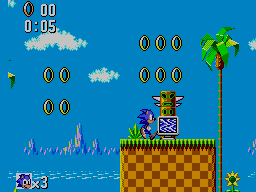Sonic al costat d’un monitor i sota diversos anells en un paisatge costaner amb palmeres.