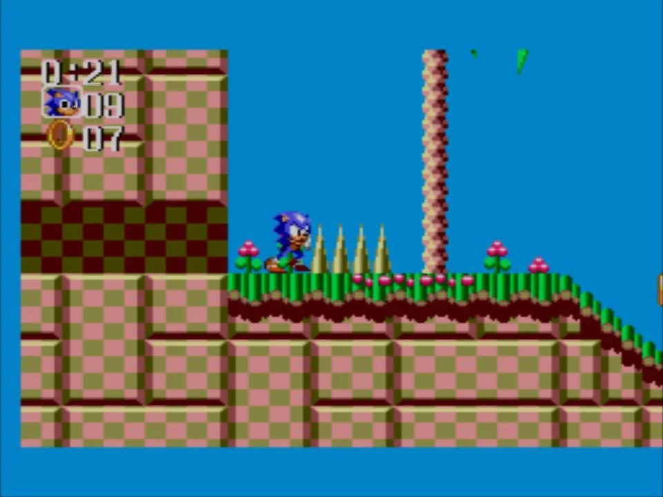 Sonic s’acosta a una filera de punxes en un terreny quadriculat i florit.
