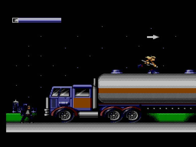 El T-800 corre damunt d’un camió cisterna de nit mentre un projectil travessa l’escena.