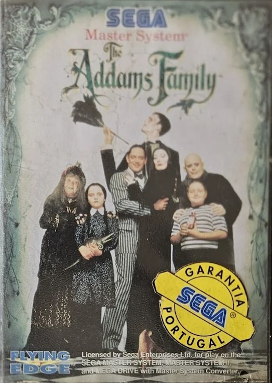 Portada portuguesa de The Addams Family per a Sega Master System amb una etiqueta groga de garantia.