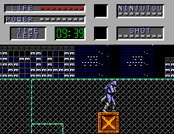 Joe Musashi damunt d'una caixa en la primera ronda, amb els indicadors LIFE, POWER, TIMER, NINJUTSU i SHOT.