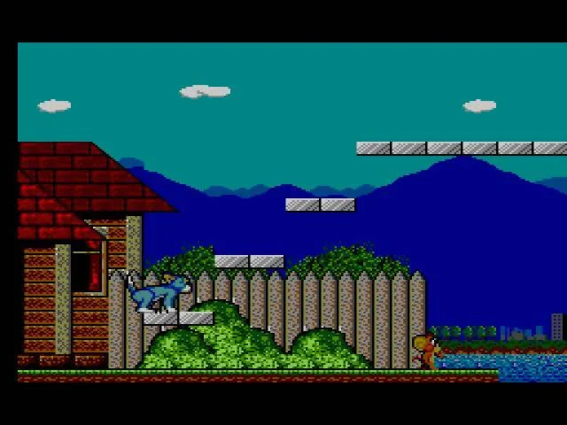 Tom al costat d’una casa mentre Jerry corre prop d’una zona d’aigua.